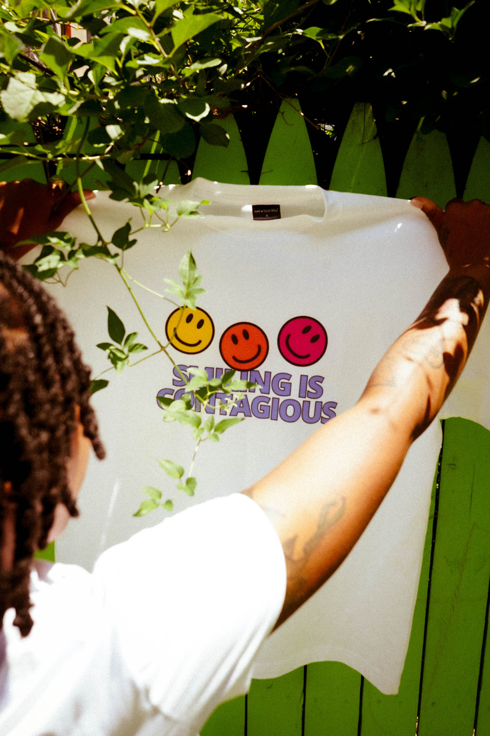 Girl-holding-up-smiling-is-contagious-shirt